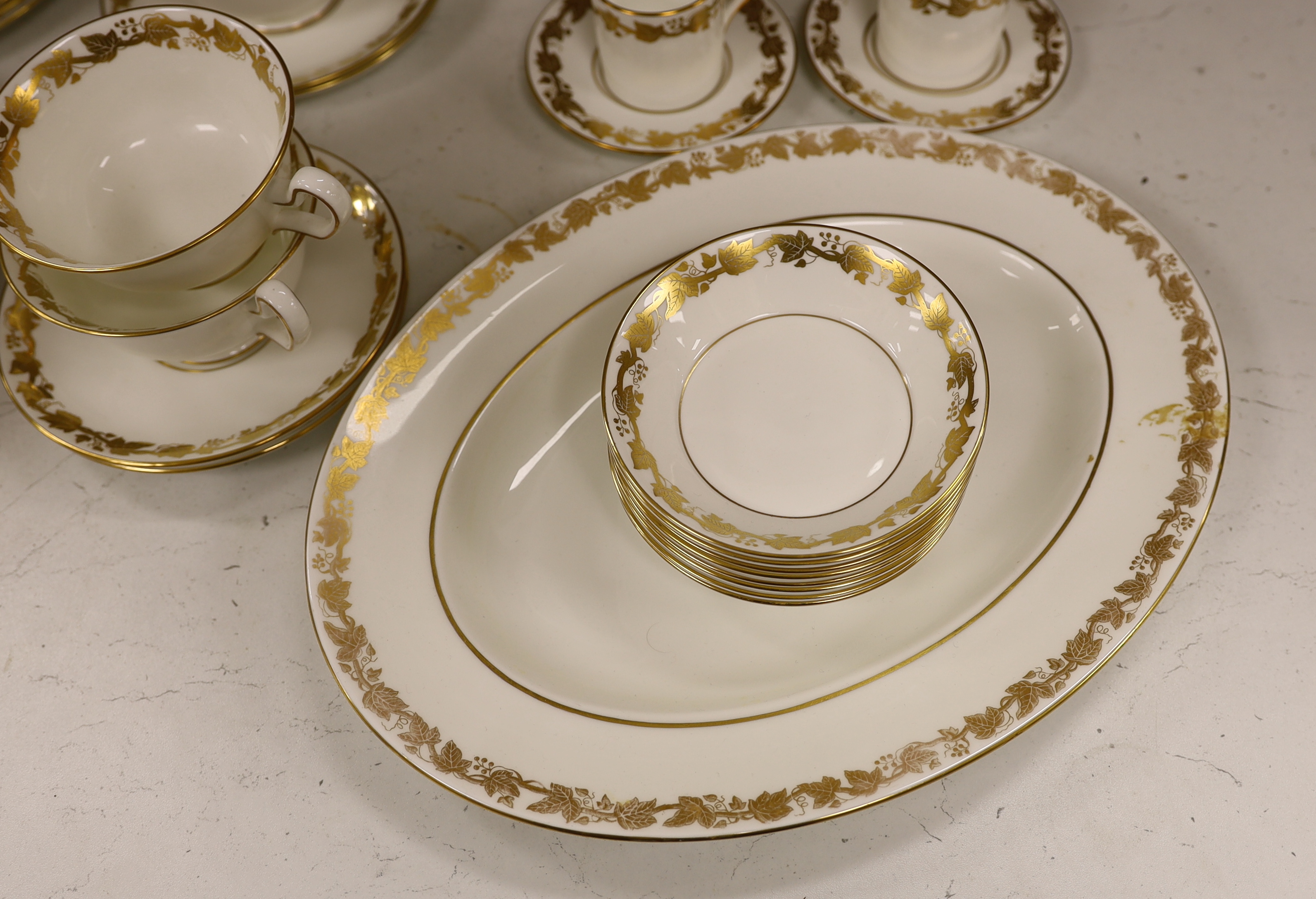 A Wedgwood gilt vine pattern dinner and coffee service for twelve